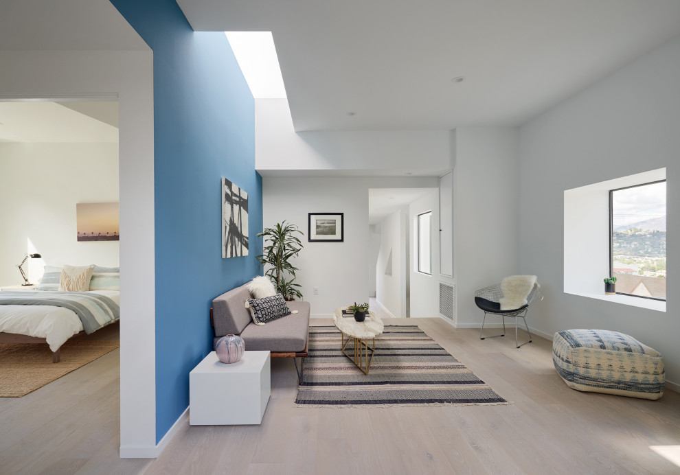 Exemple d'une salle de séjour tendance de taille moyenne et ouverte avec un mur bleu, parquet clair et un sol beige.