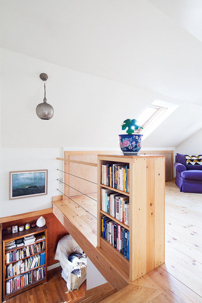 Foto di un piccolo soggiorno contemporaneo stile loft con libreria, pareti bianche, nessuna TV, parquet chiaro, nessun camino e pavimento beige