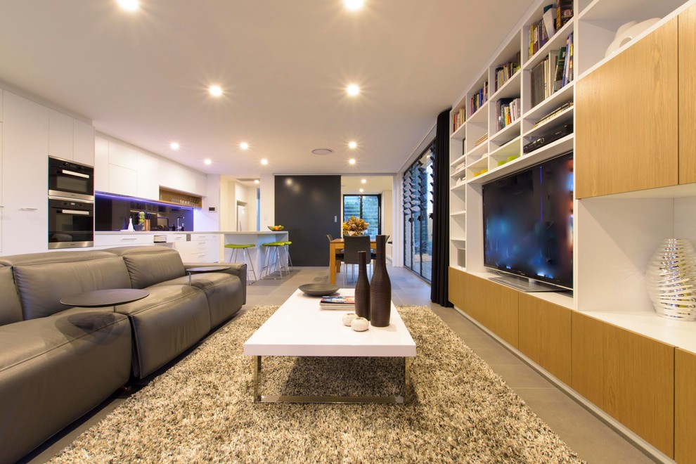 Ejemplo de sala de estar abierta pequeña con paredes blancas, suelo de baldosas de porcelana y pared multimedia
