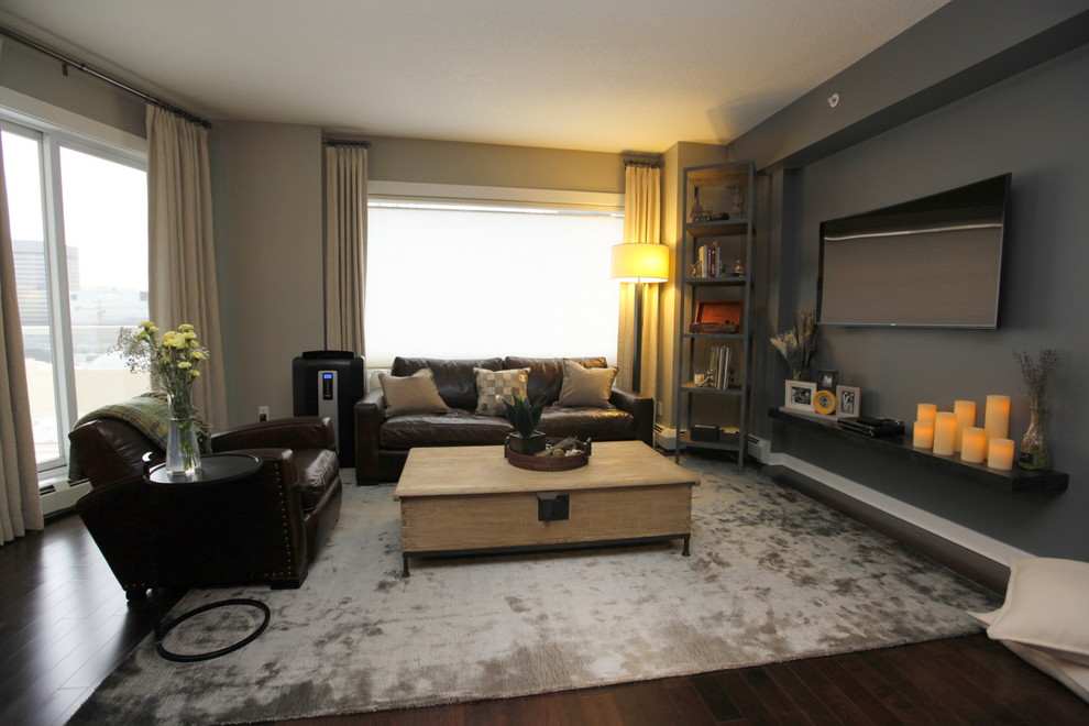 Kleines, Offenes Modernes Wohnzimmer ohne Kamin mit grauer Wandfarbe, dunklem Holzboden und TV-Wand in Edmonton