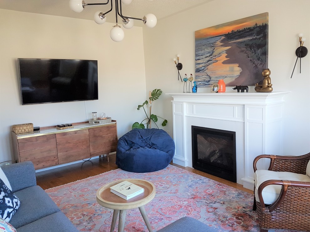Mittelgroßes, Abgetrenntes Shabby-Style Wohnzimmer mit weißer Wandfarbe, braunem Holzboden, Kamin, Kaminumrandung aus Holz, TV-Wand und gelbem Boden in Toronto