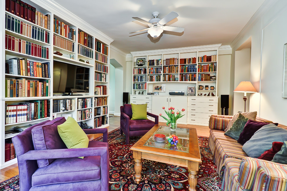 На фото: гостиная комната в классическом стиле с с книжными шкафами и полками и ковром на полу