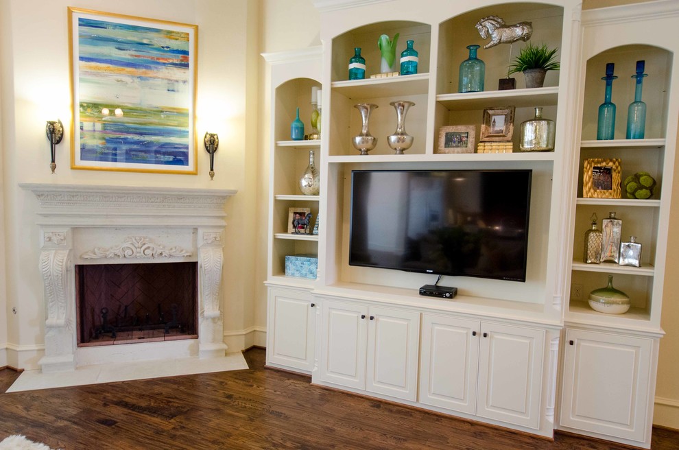 Modelo de sala de estar abierta clásica renovada grande con paredes beige, suelo de madera en tonos medios, chimenea de esquina, marco de chimenea de piedra y pared multimedia