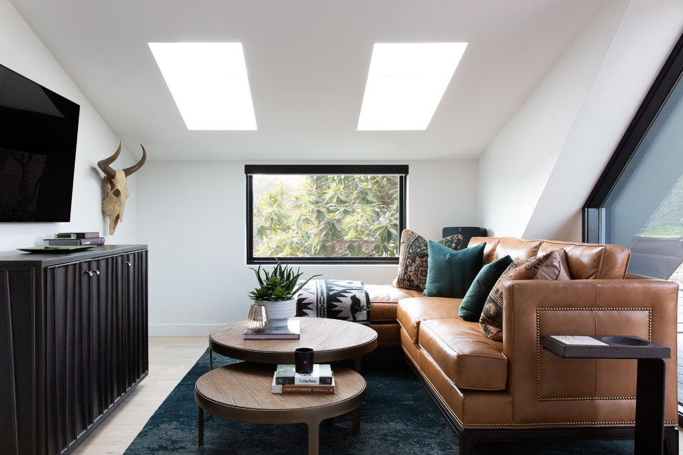 This is an example of a small modern mezzanine games room in Austin with white walls, light hardwood flooring and brown floors.