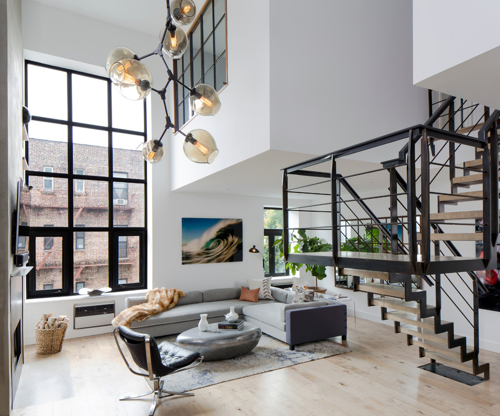 Aménagement d'un salon industriel avec un mur blanc et parquet clair.