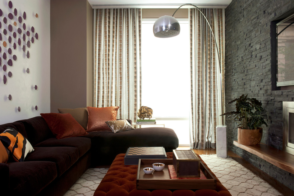 Immagine di un soggiorno contemporaneo con pareti beige e TV a parete