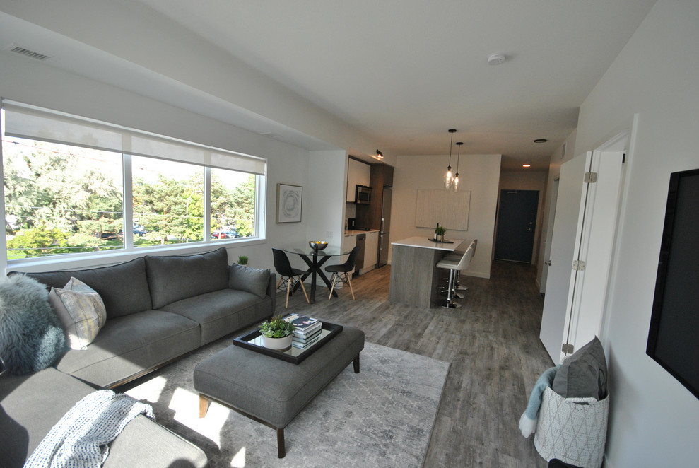 Kleines, Offenes Modernes Wohnzimmer mit weißer Wandfarbe, Vinylboden, TV-Wand und grauem Boden in Vancouver