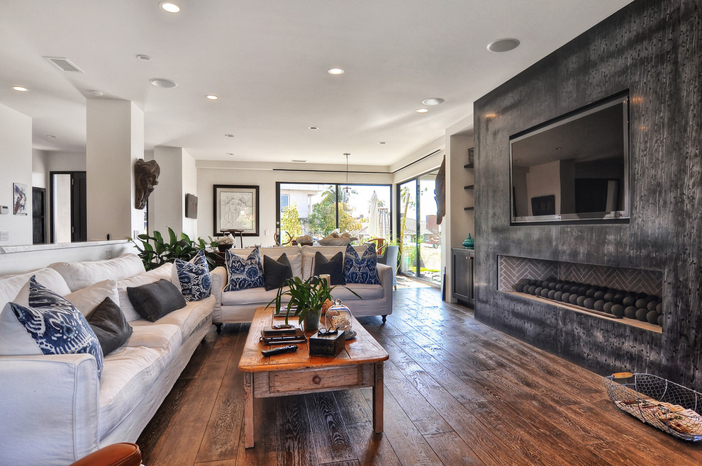 This is an example of a medium sized nautical open plan games room in Orange County with beige walls, dark hardwood flooring, a ribbon fireplace, a built-in media unit and brown floors.