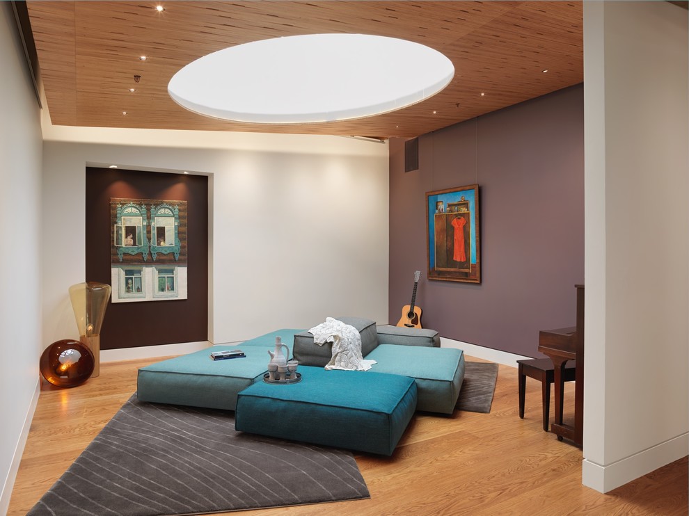 Esempio di un soggiorno design aperto con sala della musica, pareti viola, pavimento in legno massello medio e nessun camino