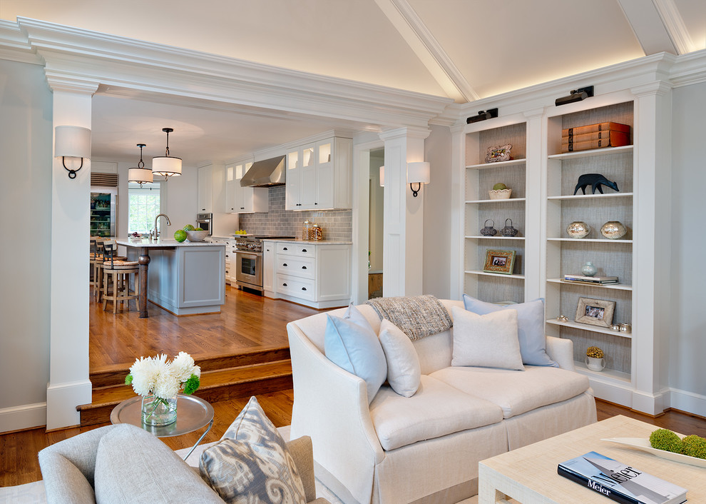 Imagen de sala de estar abierta tradicional renovada grande con suelo de madera en tonos medios, todas las chimeneas y marco de chimenea de piedra