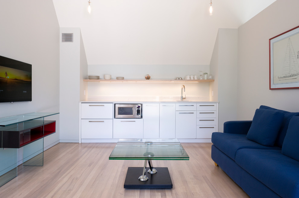 На фото: гостиная комната в современном стиле с серыми стенами и синим диваном с