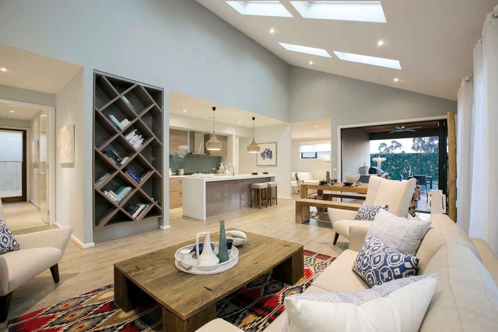Modelo de sala de estar abierta costera de tamaño medio sin chimenea con suelo de madera clara y paredes grises