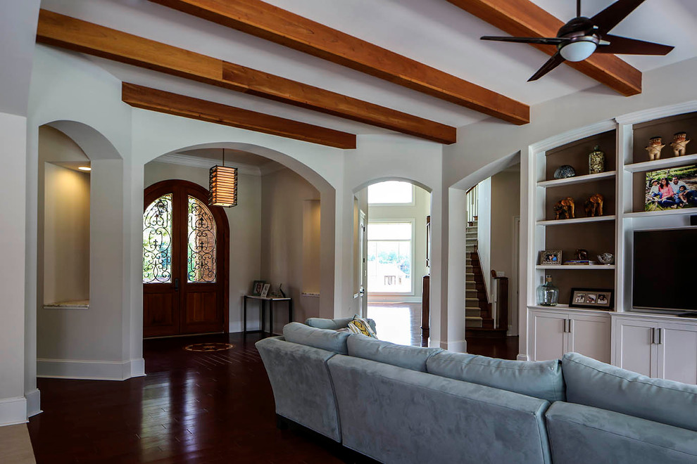 Foto de sala de estar abierta tradicional renovada de tamaño medio con paredes blancas, suelo de madera en tonos medios y pared multimedia