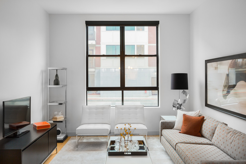 Modernes Wohnzimmer ohne Kamin mit weißer Wandfarbe, braunem Holzboden und freistehendem TV in Boston