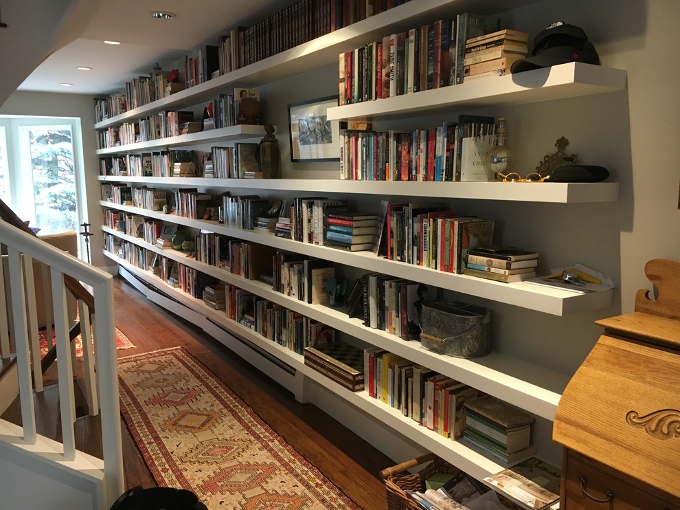 Foto di un soggiorno boho chic di medie dimensioni e chiuso con libreria, pareti grigie, parquet scuro, nessun camino, nessuna TV e pavimento marrone