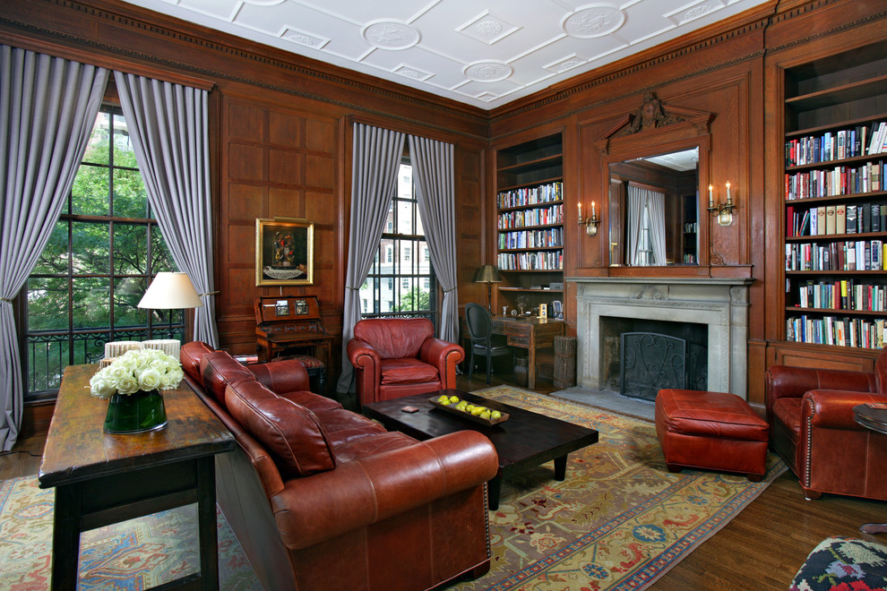Exemple d'une grande salle de séjour chic avec parquet foncé, une cheminée standard, un manteau de cheminée en pierre et une bibliothèque ou un coin lecture.