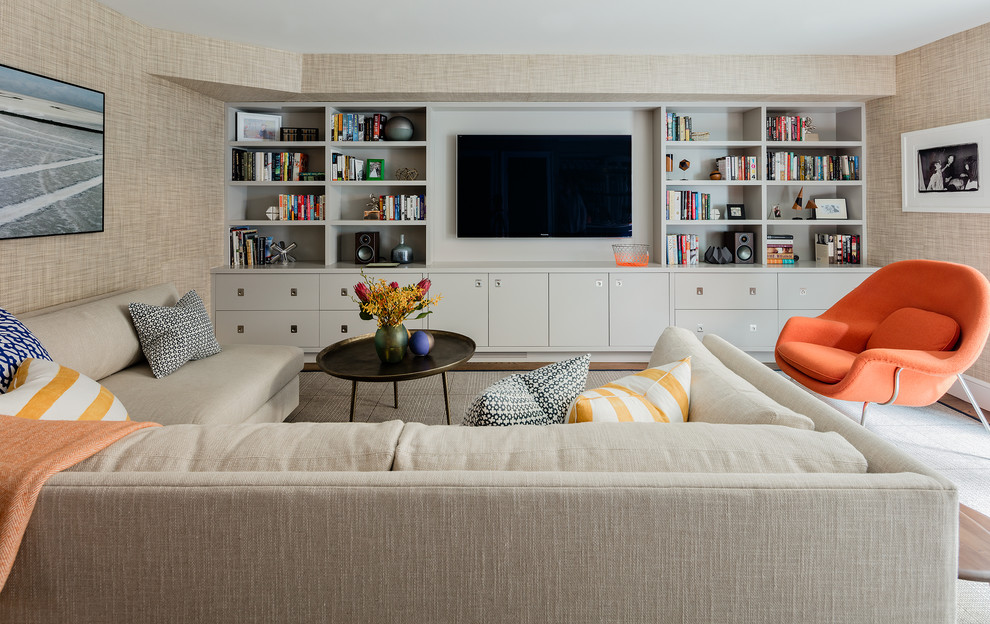 Modelo de sala de estar con barra de bar cerrada retro grande con paredes beige, suelo de madera en tonos medios y televisor colgado en la pared