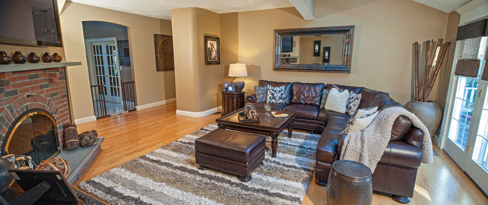 Esempio di un grande soggiorno classico chiuso con pareti beige, pavimento in legno massello medio, camino ad angolo e porta TV ad angolo
