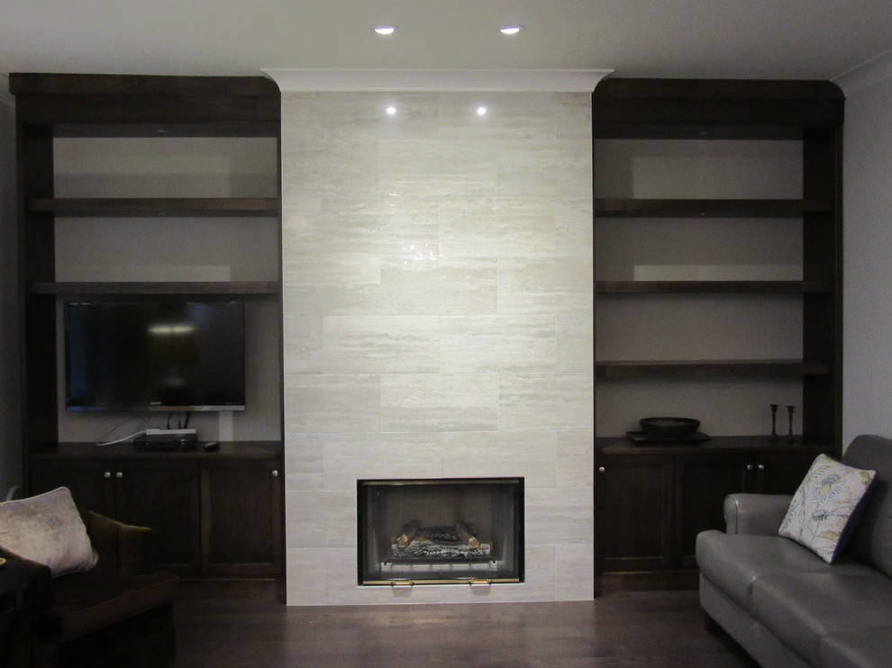 Mittelgroßes, Abgetrenntes Klassisches Wohnzimmer mit grauer Wandfarbe, braunem Holzboden, Kamin, Kaminumrandung aus Stein und Multimediawand in Vancouver