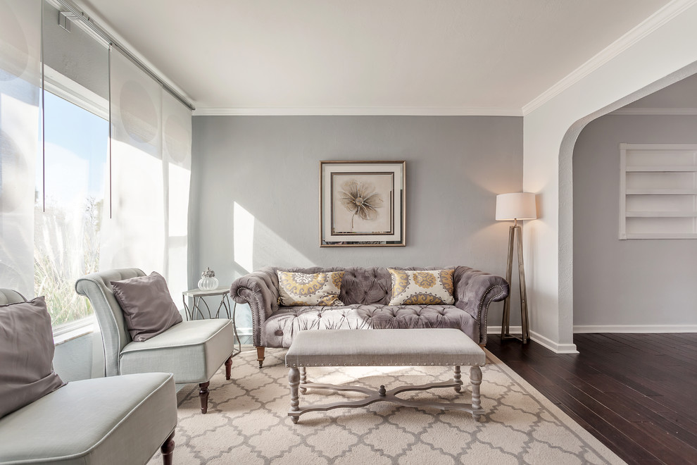 Modelo de sala de estar abierta romántica grande con paredes grises y suelo de madera oscura