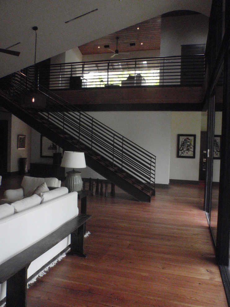 Ejemplo de sala de juegos en casa tipo loft de estilo americano extra grande con suelo de madera clara y pared multimedia