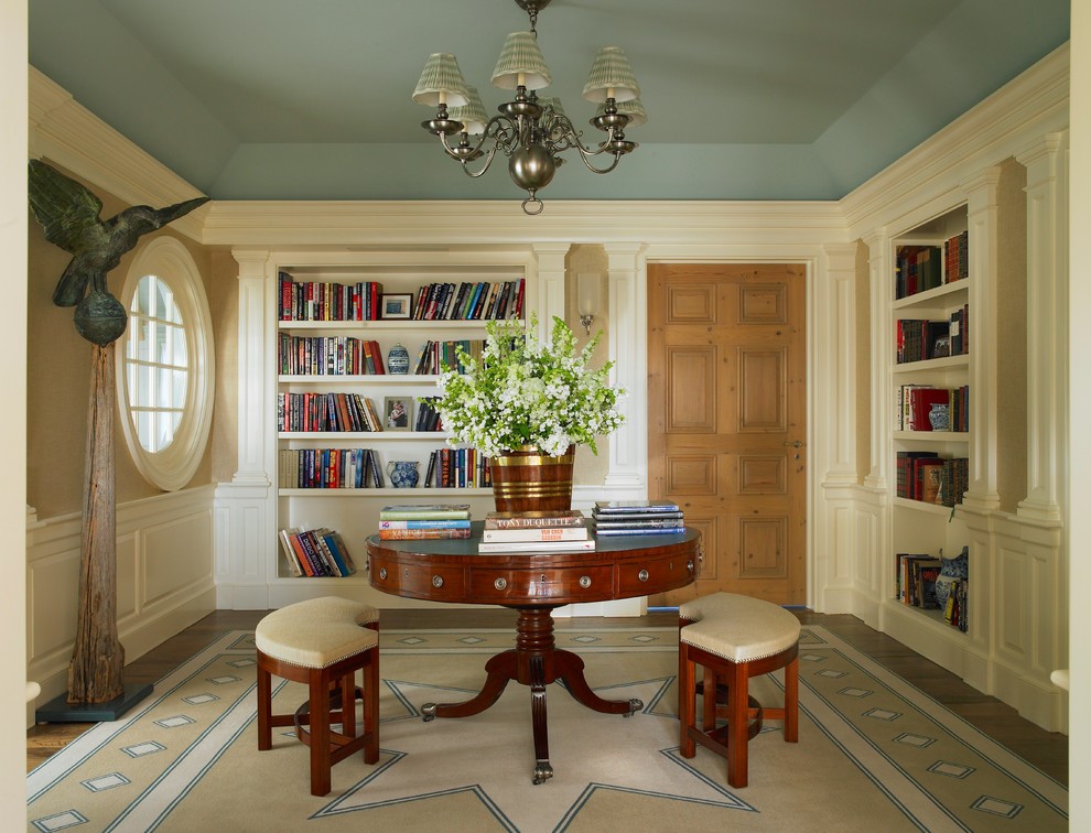 Diseño de sala de estar con biblioteca cerrada marinera sin chimenea y televisor con paredes beige y suelo de madera en tonos medios