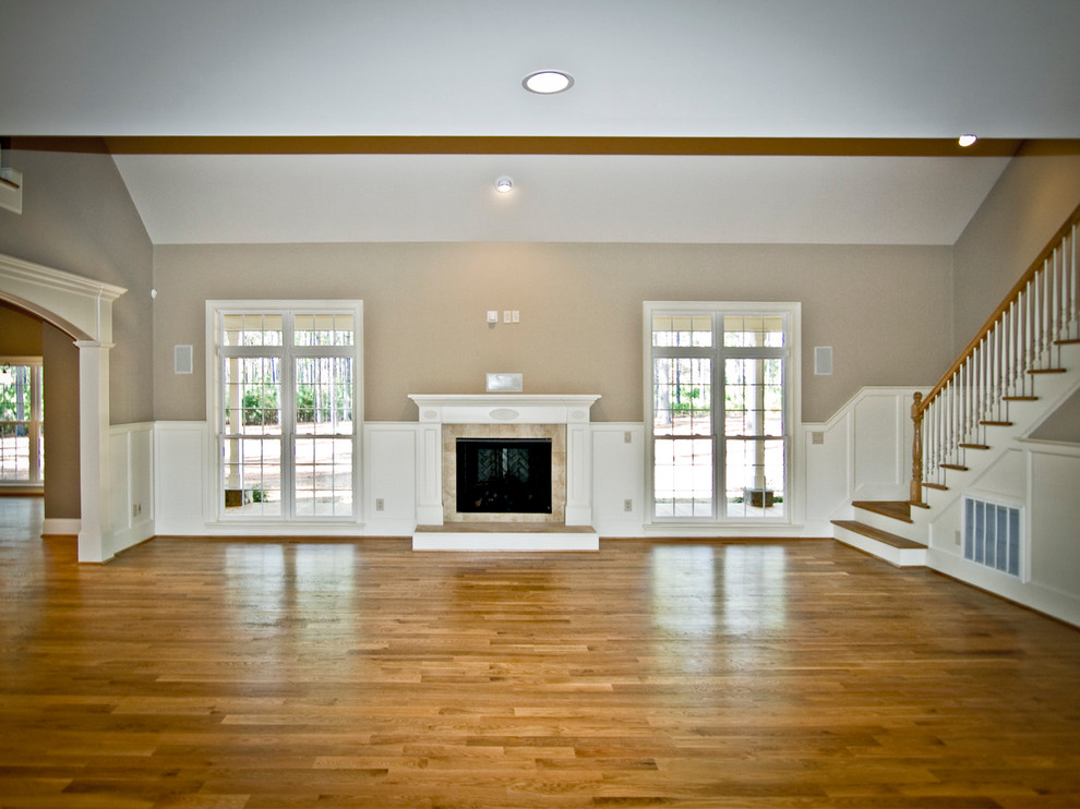 Large elegant open concept medium tone wood floor family room photo in Raleigh with beige walls, a standard fireplace and a tile fireplace