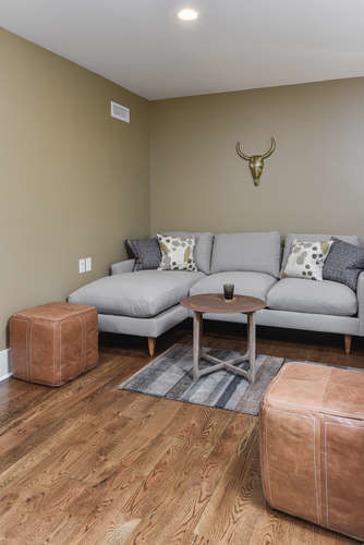 Diseño de sala de estar abierta de estilo americano pequeña sin chimenea con paredes beige, suelo de madera en tonos medios y suelo marrón