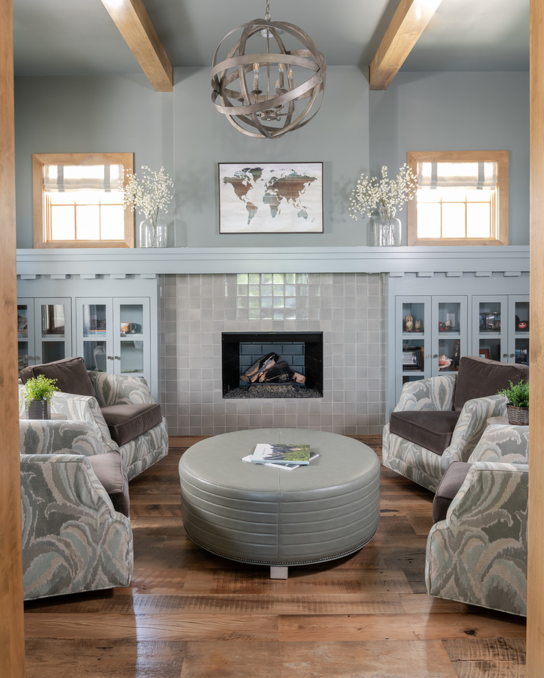 Klassisches Wohnzimmer mit blauer Wandfarbe, braunem Holzboden, Kamin, gefliester Kaminumrandung und braunem Boden in Dallas