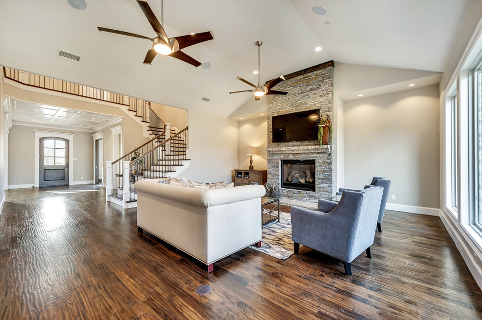 Inspiration for a large classic open plan games room in Dallas with medium hardwood flooring, a standard fireplace, a stone fireplace surround and a wall mounted tv.