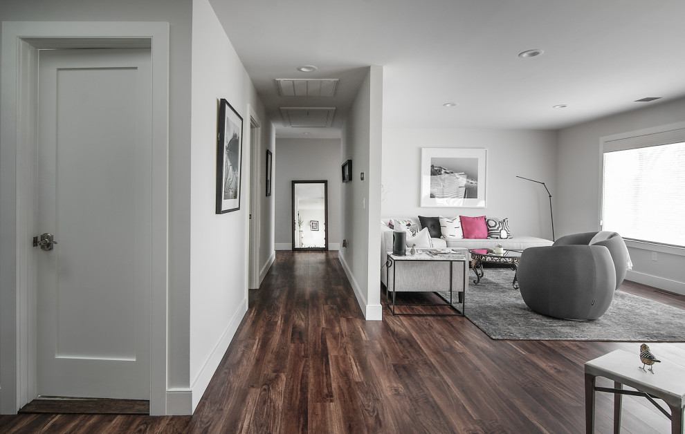 Diseño de sala de estar abierta minimalista de tamaño medio sin televisor con paredes grises, suelo vinílico, chimenea de doble cara y suelo marrón