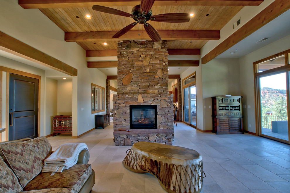 Imagen de sala de estar abierta de estilo de casa de campo con suelo de piedra caliza, chimenea de doble cara, marco de chimenea de piedra y suelo blanco