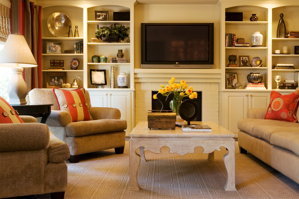 Mid-sized elegant enclosed carpeted family room photo in Portland with a standard fireplace, a brick fireplace, beige walls and a wall-mounted tv