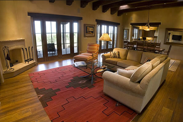 This is an example of a large open plan games room in Albuquerque with beige walls, medium hardwood flooring, a corner fireplace and a plastered fireplace surround.