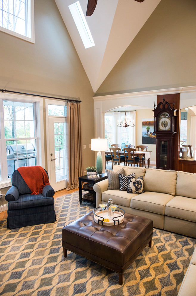 Esempio di un grande soggiorno classico aperto con pareti beige, pavimento in legno massello medio e parete attrezzata