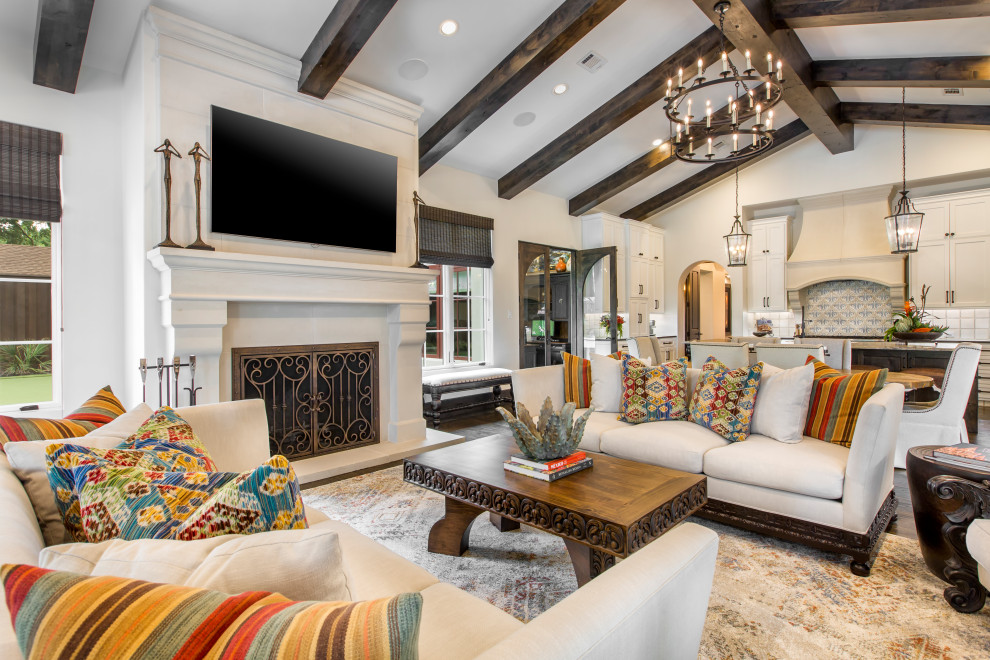 Family room - mediterranean open concept dark wood floor, brown floor and vaulted ceiling family room idea in Dallas with white walls, a standard fireplace and a wall-mounted tv