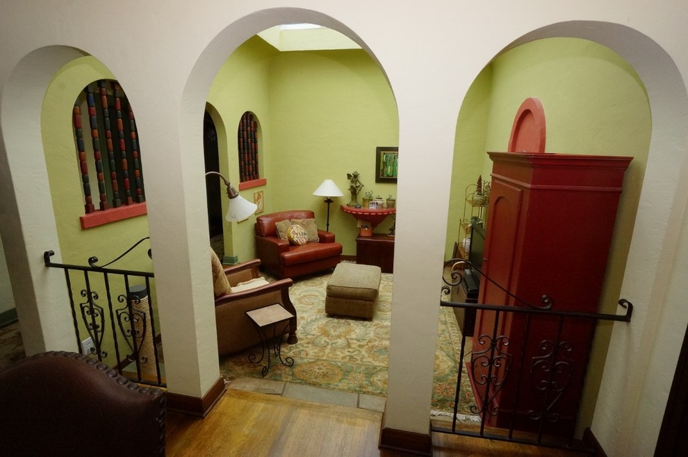 Kleines, Abgetrenntes Klassisches Wohnzimmer mit grüner Wandfarbe, braunem Holzboden und TV-Wand in Los Angeles