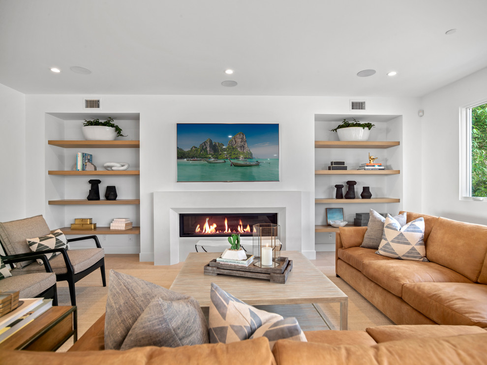 Inspiration for a beach style games room in Orange County with white walls, light hardwood flooring, a ribbon fireplace, a wall mounted tv and beige floors.