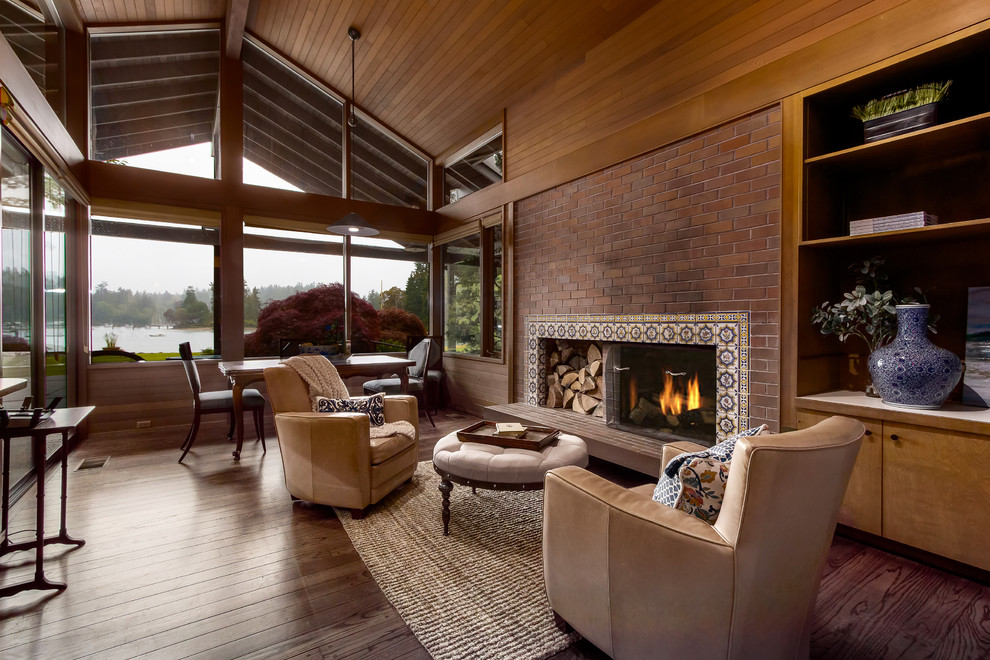 Idée de décoration pour une grande salle de séjour design ouverte avec un mur marron, un sol en bois brun, une cheminée standard, un manteau de cheminée en carrelage et un sol marron.
