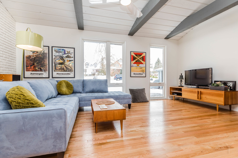 Foto di un soggiorno minimalista di medie dimensioni e aperto con pareti bianche, pavimento in legno massello medio, TV autoportante e pavimento marrone