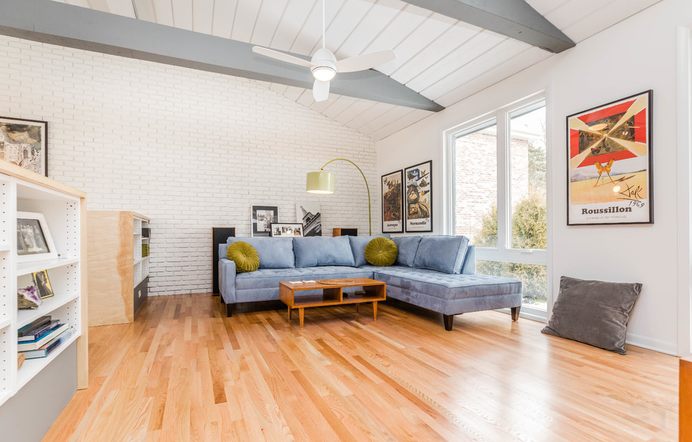 Mittelgroßes, Offenes Mid-Century Wohnzimmer mit weißer Wandfarbe, braunem Holzboden, freistehendem TV und braunem Boden in Chicago