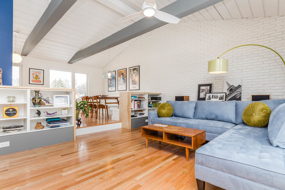 Imagen de sala de estar abierta vintage de tamaño medio con paredes blancas, suelo de madera en tonos medios, televisor independiente y suelo marrón