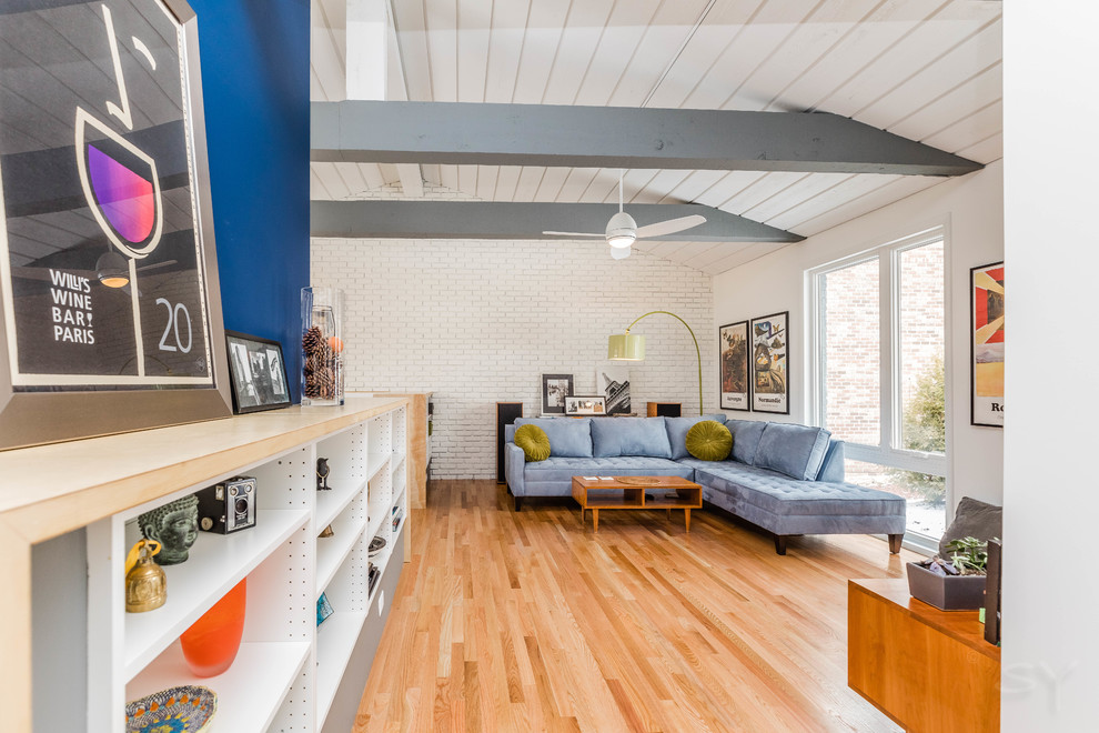 Esempio di un soggiorno minimalista di medie dimensioni e aperto con pareti bianche, pavimento in legno massello medio, TV autoportante e pavimento marrone