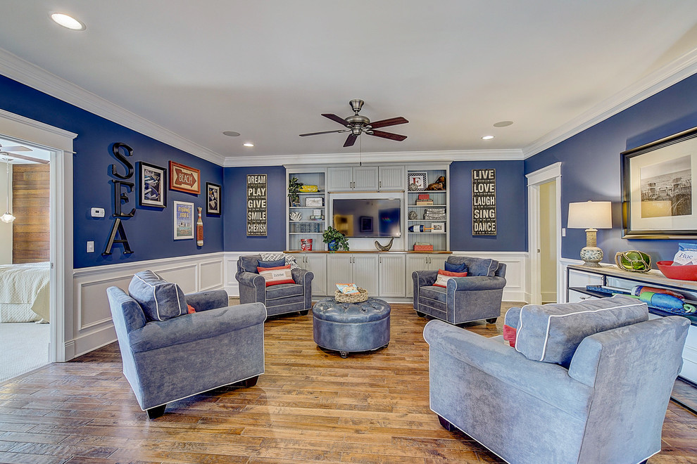 Modelo de sala de estar tipo loft de estilo americano grande con paredes azules, suelo de madera en tonos medios, pared multimedia, suelo marrón y boiserie