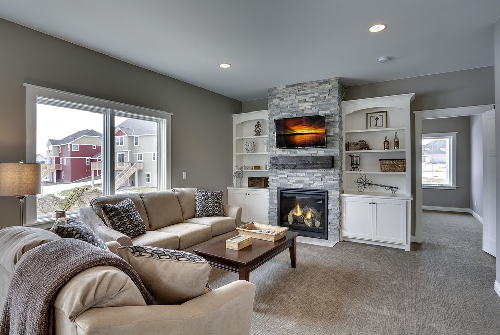 Example of a mid-sized arts and crafts open concept carpeted family room design in Minneapolis with a standard fireplace, a stone fireplace, a wall-mounted tv and gray walls
