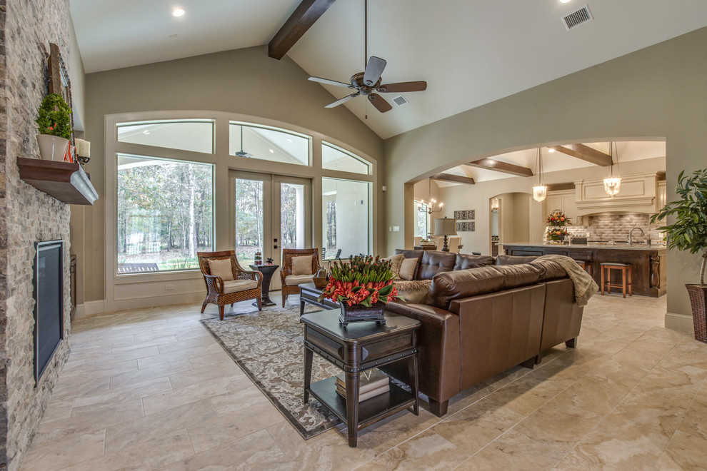 Large tuscan open concept ceramic tile and beige floor family room photo in Houston with beige walls, a standard fireplace, a stone fireplace and a tv stand