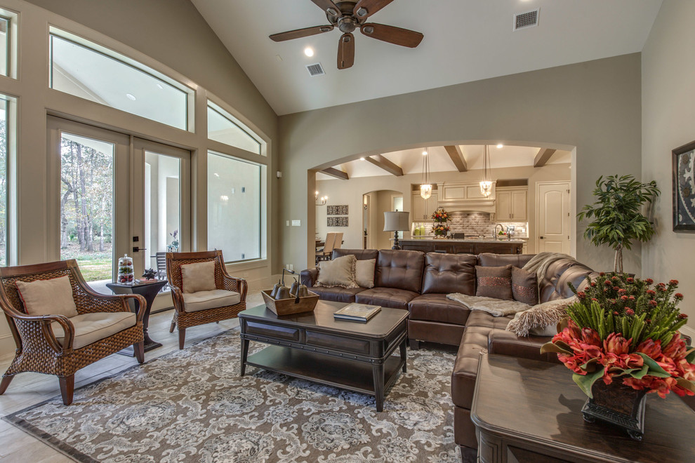 Large tuscan open concept ceramic tile and beige floor family room photo in Houston with beige walls