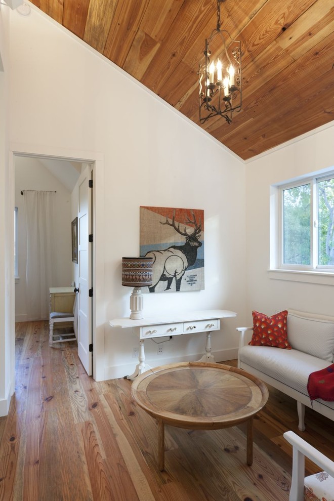 Diseño de sala de estar campestre sin televisor con paredes blancas y suelo de madera en tonos medios