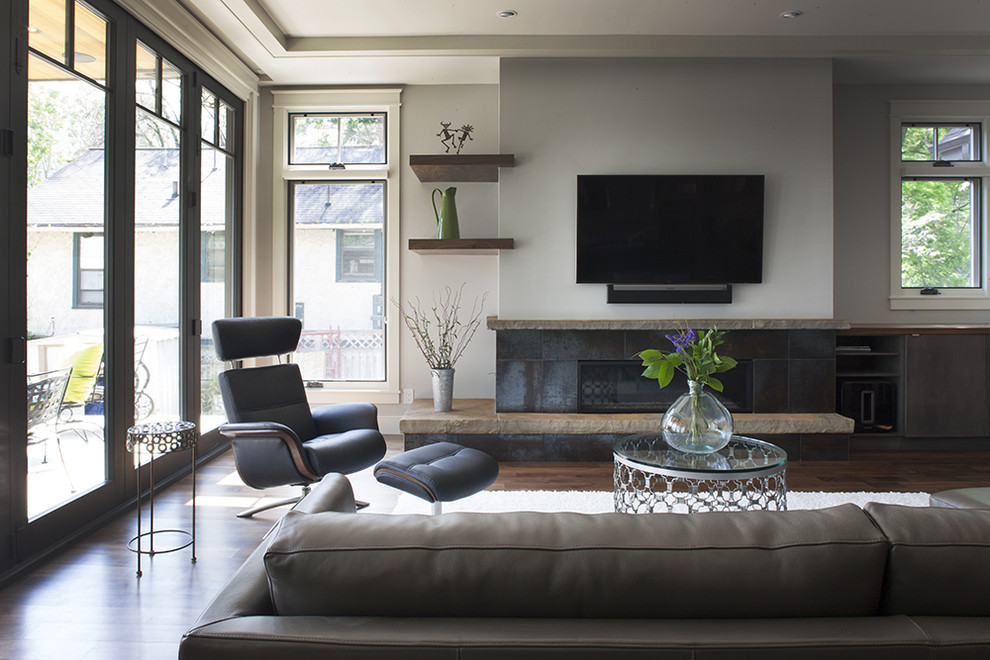 Imagen de sala de estar abierta contemporánea de tamaño medio con paredes grises, suelo de madera oscura, chimenea lineal, marco de chimenea de baldosas y/o azulejos y televisor colgado en la pared