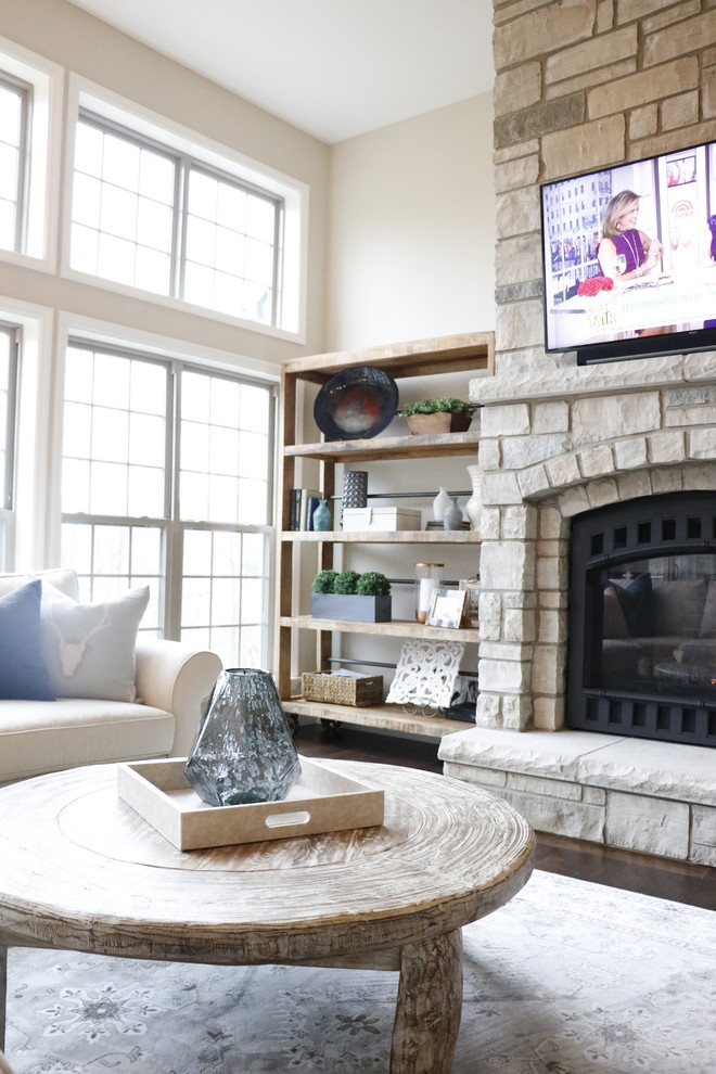 Inspiration for a medium sized traditional open plan games room in St Louis with beige walls, dark hardwood flooring, a standard fireplace, a stone fireplace surround and a wall mounted tv.